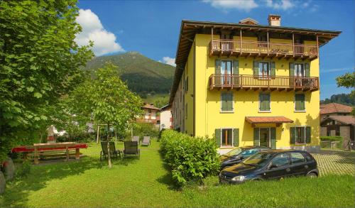 a yellow building with a car parked in front of it at Casa Elena in Ledro