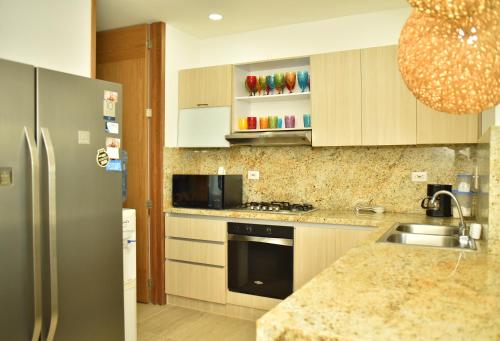 a kitchen with a sink and a refrigerator at Magico Apartamento Frente al Mar 3 Habitaciones CV41 in Coveñas