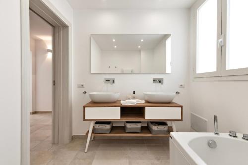 een witte badkamer met 2 wastafels en een bad bij Doberdò Exclusive House & SPA Bath - SIT Apartment in Carmiano