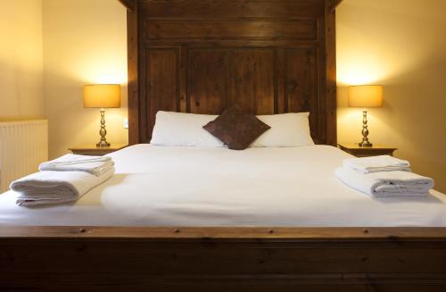 a bedroom with a large white bed with two lamps at Avon Causeway Hotel in Christchurch