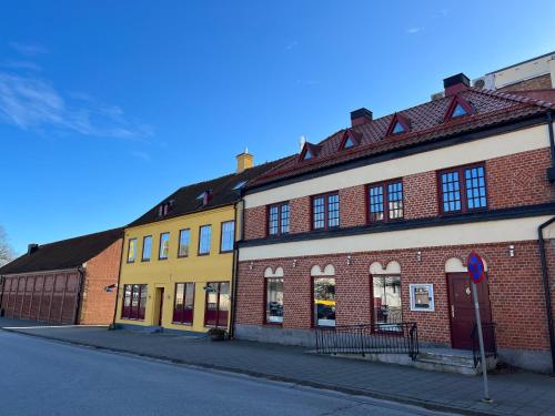 budynek z żółtej i czerwonej cegły na ulicy w obiekcie Sveriges minsta Hotell! Hôtel Gruyère w mieście Landskrona