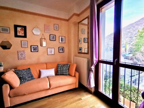 a living room with a couch and a large window at AL LAGO by Design Studio in Bellano