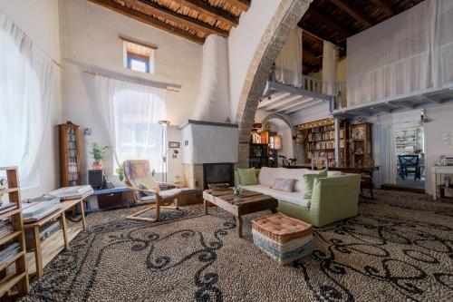 a living room with a couch and a fireplace at Artistic Home- 250yr old traditional village house in Koskinou