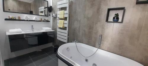 a bathroom with a bath tub and a sink at KASSANOS "La Garenne" in Privas