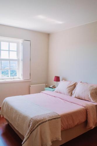 a bedroom with a large bed and a window at Just like Home - Number 8 em Quinta das Mineirinhas in Vila Nova de Cerveira
