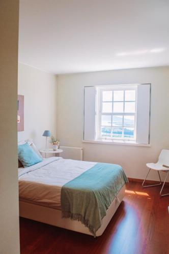 a bedroom with a bed and a window at Just like Home - Number 8 em Quinta das Mineirinhas in Vila Nova de Cerveira
