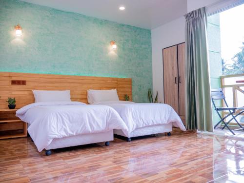 a bedroom with two beds with white sheets at Turtle Maldives - Your Gateway to the Beach & Marine Adventures Await! in Omadhoo