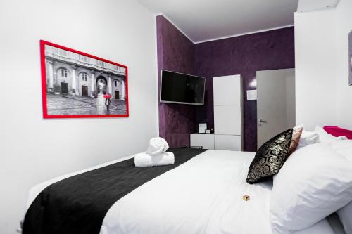 a bedroom with a large bed and a tv at Relais Circo Massimo in Rome