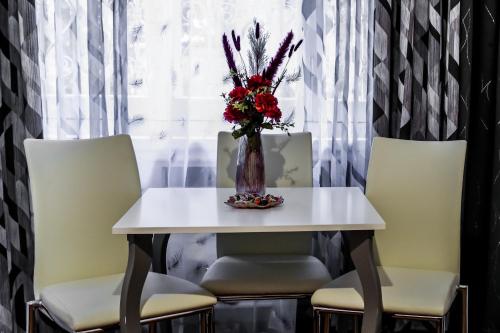 a table and chairs with a vase of flowers on it at Relais Circo Massimo in Rome