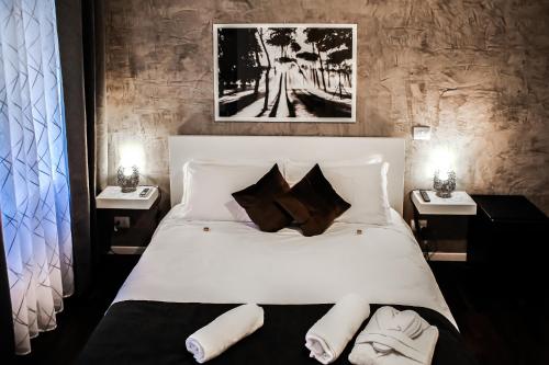 ein Schlafzimmer mit einem großen weißen Bett mit zwei Nachttischen in der Unterkunft Relais Circo Massimo in Rom
