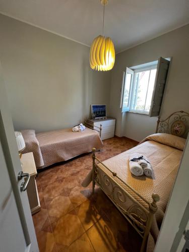 a bedroom with two beds and a window and a chandelier at casamare 69 in Torre Canne