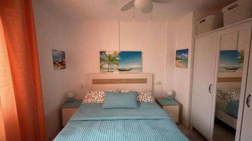 um pequeno quarto com uma cama e duas mesas em Isla Verde Apartment em Torrevieja