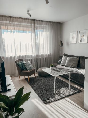a living room with a bed and a coffee table at Marijampole Apartment with FREE Parking in Marijampolė