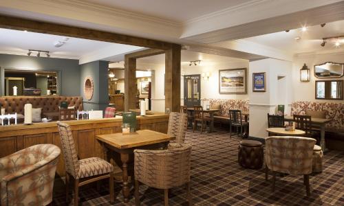 a restaurant with tables and chairs and a bar at Avon Causeway Hotel in Christchurch