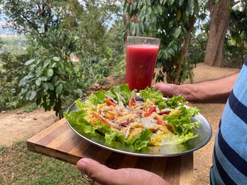 a plate of salad and a drink on a table at Pearl's Homestay Matale in Matale