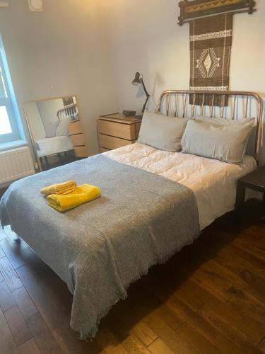 una camera da letto con un letto e un asciugamano giallo di Spacious 1-bed flat in North Kensington a Londra