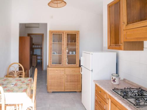 a kitchen with a white refrigerator and wooden cabinets at La Grazia in Parghelia