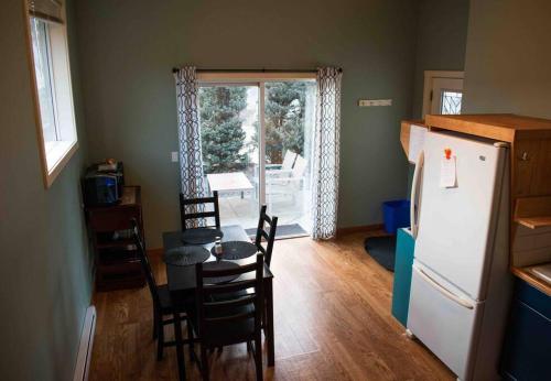 a kitchen with a table and chairs and a refrigerator at Oyama house- close to beach in Lake Country