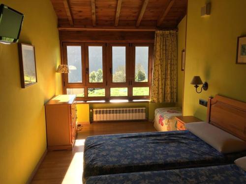 a bedroom with a bed and a large window at LA LLANADA in Cangas de Onís