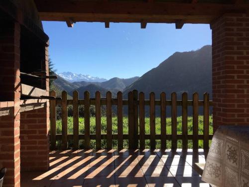 a porch with a fence and mountains in the background at LA LLANADA in Cangas de Onís