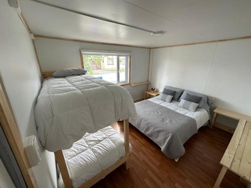 a small bedroom with two beds and a window at Patagonia Sweet Home in Puerto Natales