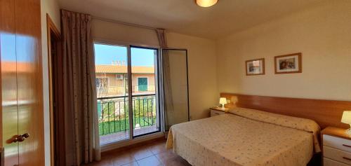 een slaapkamer met een bed en een groot raam bij Casa Mas Pinell 93 in Torroella de Montgrí
