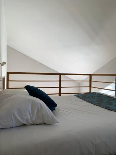 a large white bed with two pillows on it at Hôtel L'ile Du Saussay in Itteville