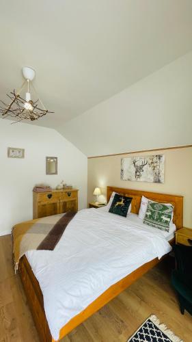 a bedroom with a large bed with white sheets at Casa de Sub Munte Fundata in Fundata