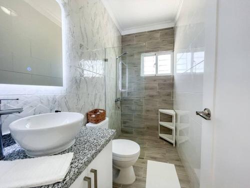 ein weißes Bad mit einem Waschbecken und einem WC in der Unterkunft Villa Ana Luisa - Pool, AC, 3min to Beach, Modern 3BD/3.5BA in La Romana