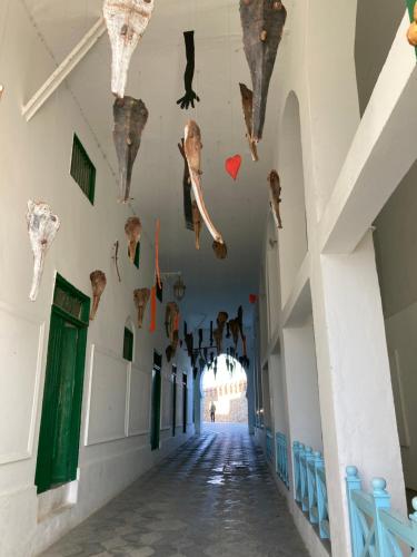 a hallway of a building with fish hanging from the ceilings at Dar Said in Asilah