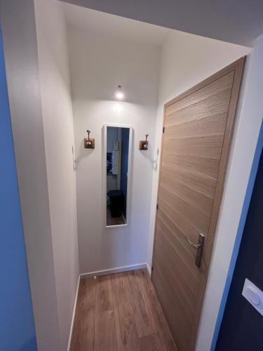 - un couloir avec une porte en bois et un miroir dans l'établissement Le Lumineux, au Havre