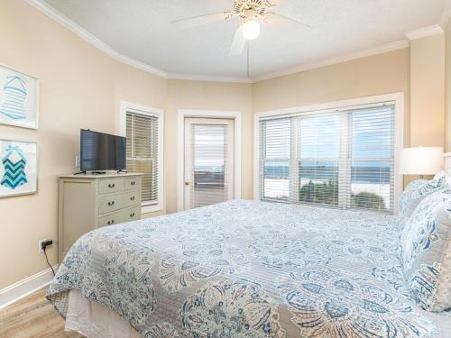 een slaapkamer met een bed, een tv en ramen bij Sandpiper 205 in Tybee Island