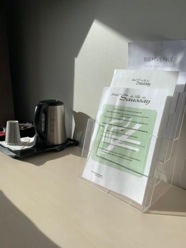 a box sitting on top of a table with a coffee mug at Hôtel L'ile Du Saussay in Itteville
