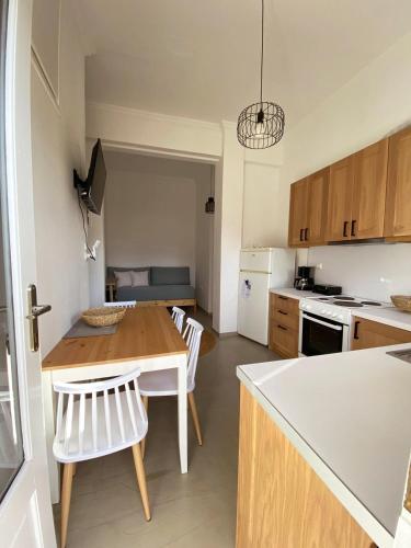 a kitchen with a table and chairs in a room at Thassa Beach Apartment No6 (with mountain view) in Leonidion