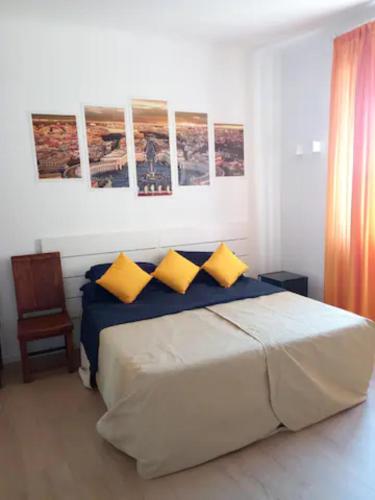 - une chambre avec un grand lit et des oreillers jaunes dans l'établissement Piazza San Pietro Suite, à Rome