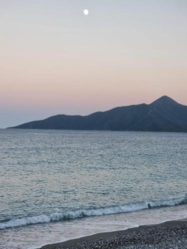 a view of the ocean with mountains in the background at Thassa Beach Apartment No6 (with mountain view) in Leonidion