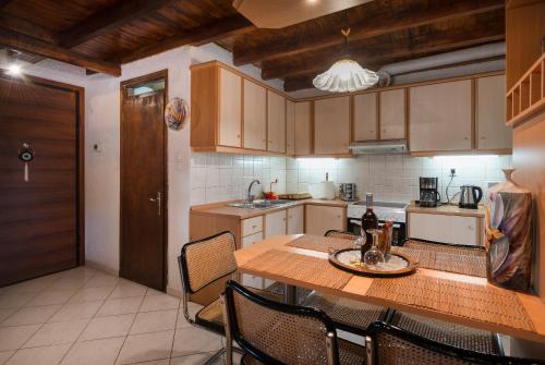 a kitchen with a wooden table with chairs and a tableasteryasteryasteryasteryastery at Chalet Renata 2 Livadi Arachovas in Kalívia