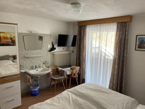 um quarto de hotel com uma cama e um lavatório em Haus Grünstein em Biberwier