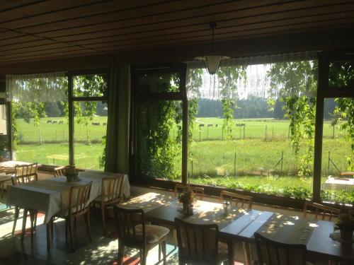 a dining room with tables and chairs and a view of a field at Landhotel Gasthof Eichhof Natters in Innsbruck