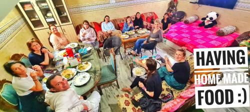 a group of people sitting in a room eating food at Anukampa Paying Guest House in Agra