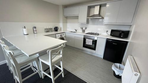 a kitchen with white cabinets and a white counter top at Hosted By Ryan - 1 Bedroom Apartment in Liverpool