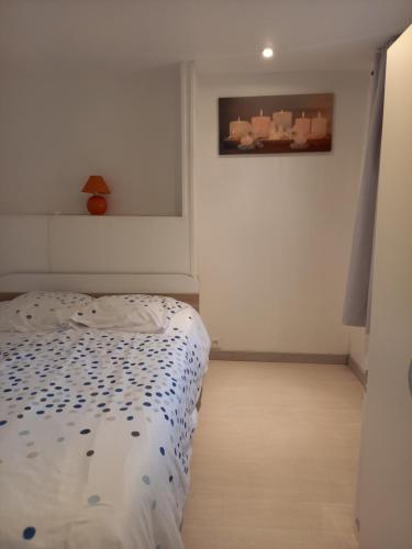 1 dormitorio con 1 cama y una pintura en la pared en Ile breizh, en Ploubezre