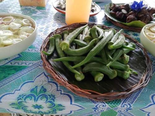 a basket of green peppers on a table at Jolits Ecogarden Integrated Farm in Batuan