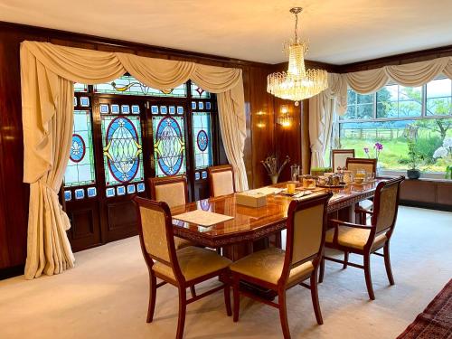 a dining room with a table and chairs and stained glass windows at FINN VILLAGE Loch Lomond Villa - THE BLACK ROOM with Private Jacuzzi-Style Bath in Drymen