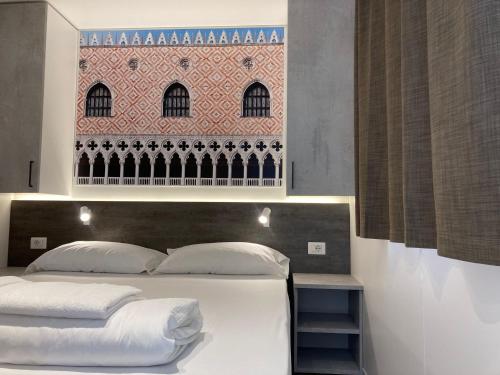 Un dormitorio con una cama blanca con una foto en la pared en Camping Venezia Village en Mestre