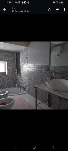 a bathroom with two sinks and a tub and a mirror at Casetta del cuore intero appartamento con camino in Sadali