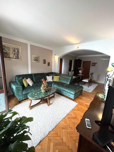 a living room with a green couch and a table at Apartments Dijana in Kotor