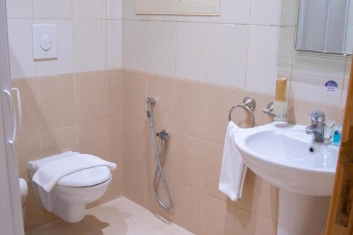 a bathroom with a toilet and a sink at سويتس المقام in Makkah