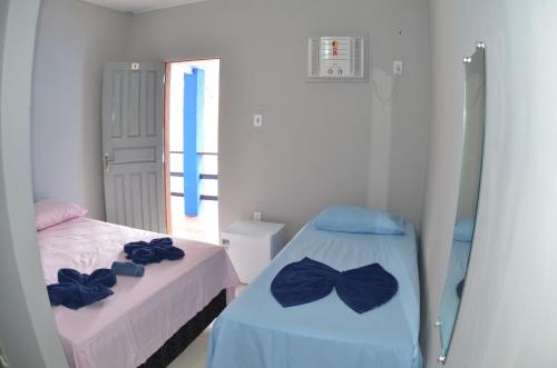 a bedroom with two beds with bow ties on them at Suítes good trip Itacare sem estacionamento in Itacaré