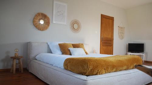 ein Schlafzimmer mit einem Bett mit einer Decke darauf in der Unterkunft Chez Bérénice et Clément in Miraumont
